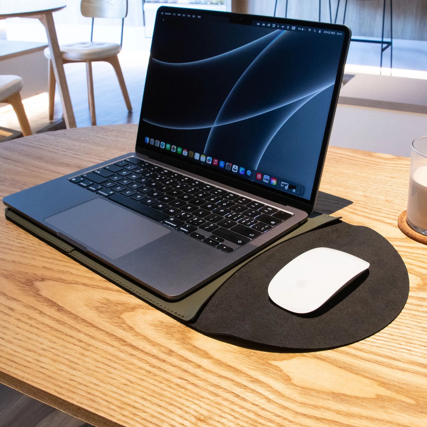 Antibacterial 3-in-1 MacBook leather sleeve in olive green, in use during a lifestyle shot.