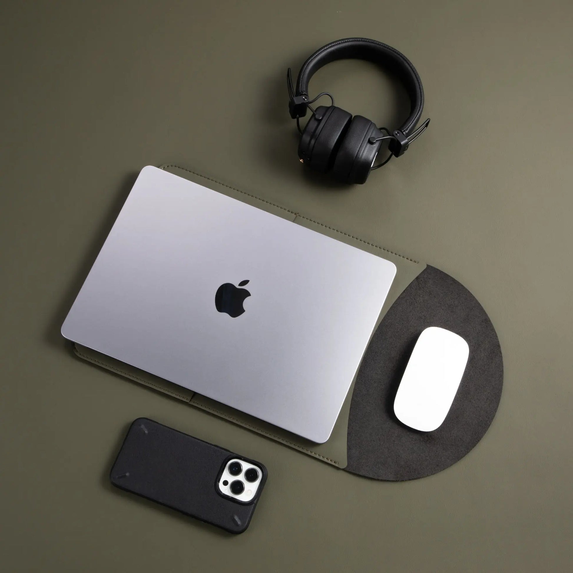 Usage view of antibacterial 3-in-1 MacBook leather sleeve in olive green with MacBook and Magic Mouse.