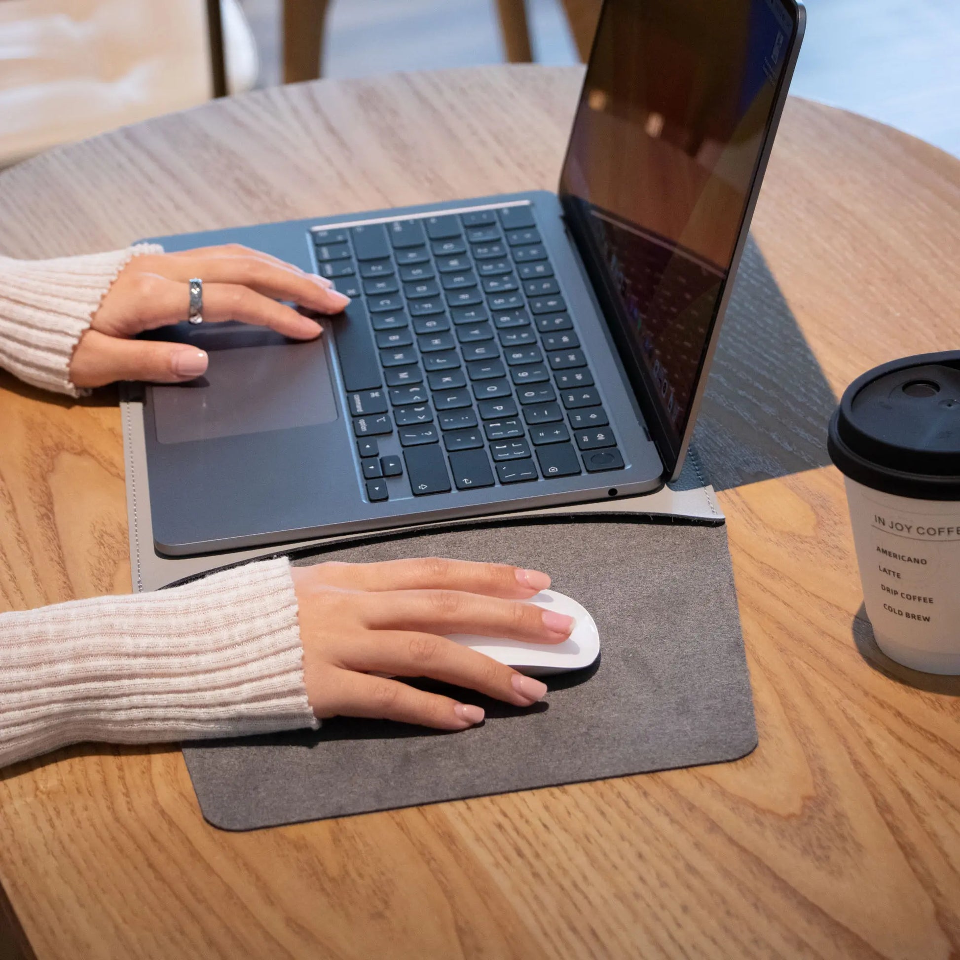 Lifestyle shot of slim 3-in-1 MacBook sleeve with built-in square mouse pad - light gray.